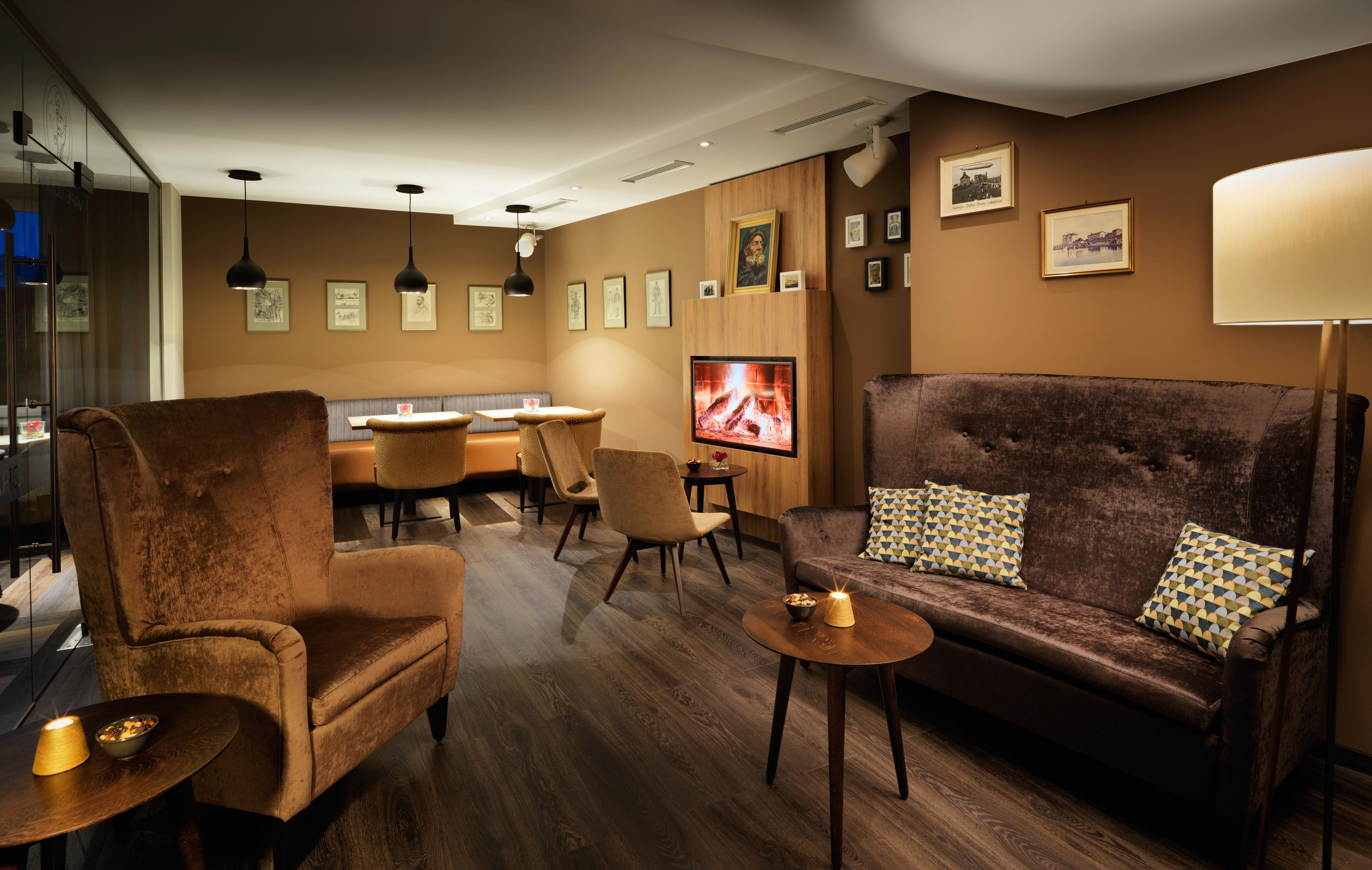 Uma sala de estar aconchegante com sofá, poltronas, televisão e um espaço de jantar com mesa e cadeiras.