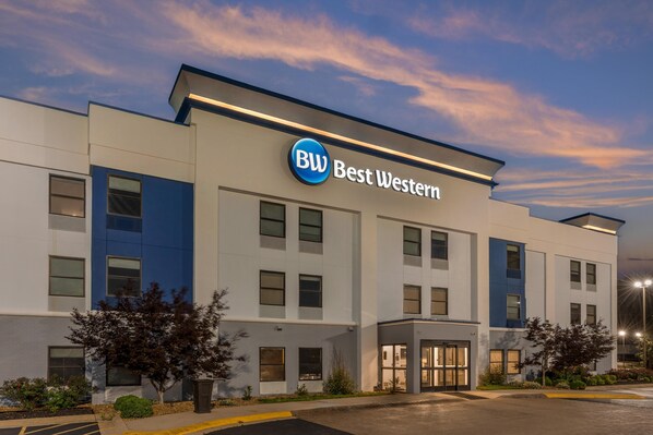 A modern Best Western hotel building with a prominent sign, multiple windows, and a well-lit entrance.