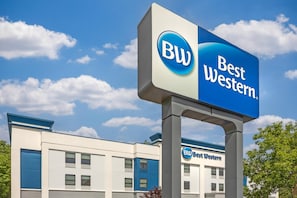 A Best Western hotel sign with a clear blue sky and clouds in the background.