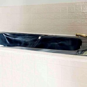 A bathtub with a faucet and a drain.