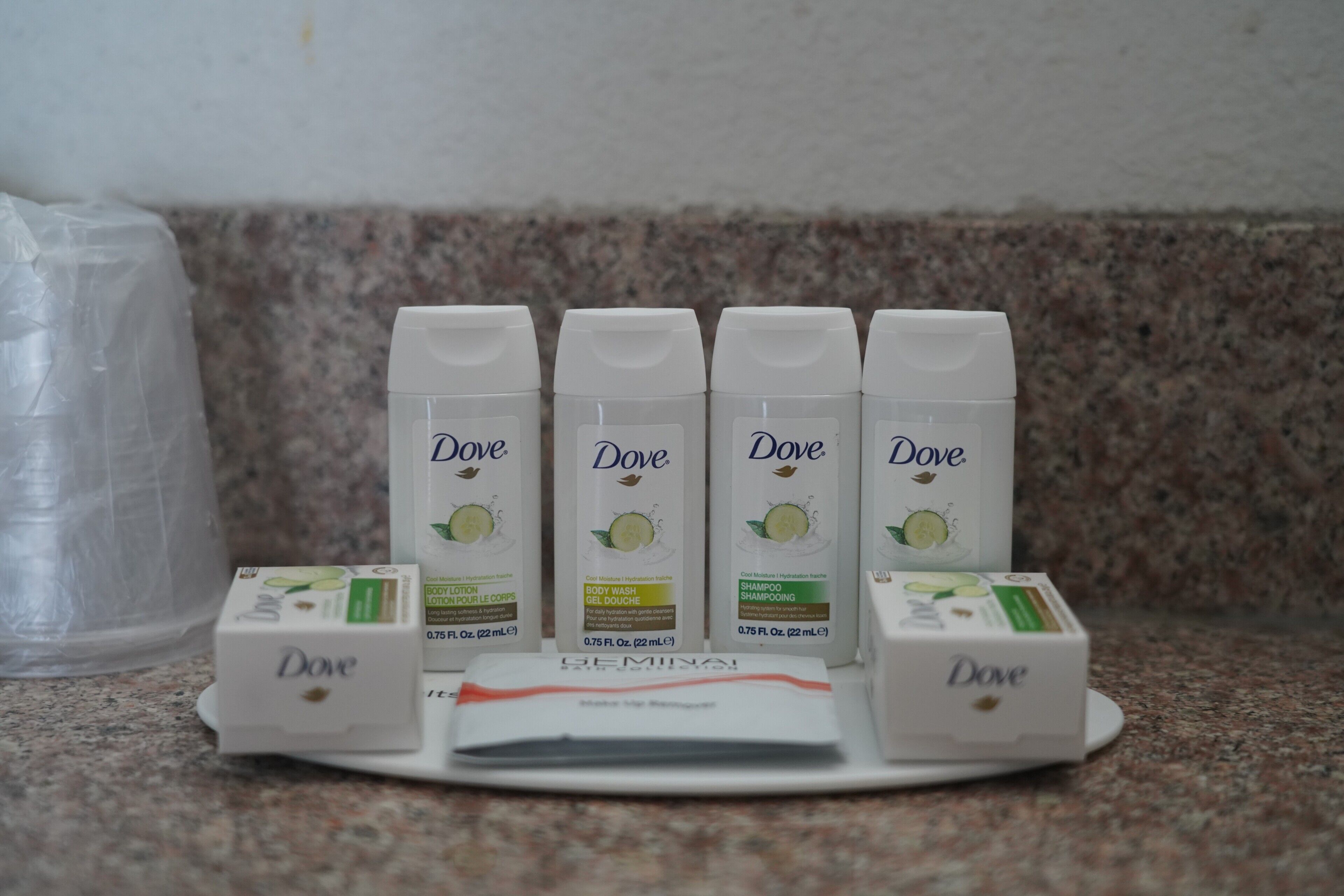 Flaconi di bagnoschiuma, shampoo e lozione Dove disposti su un piano di lavoro.