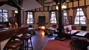 A pub with a fireplace, wooden furniture, and a bar area. - Cresta Churchill (Bulawayo)
