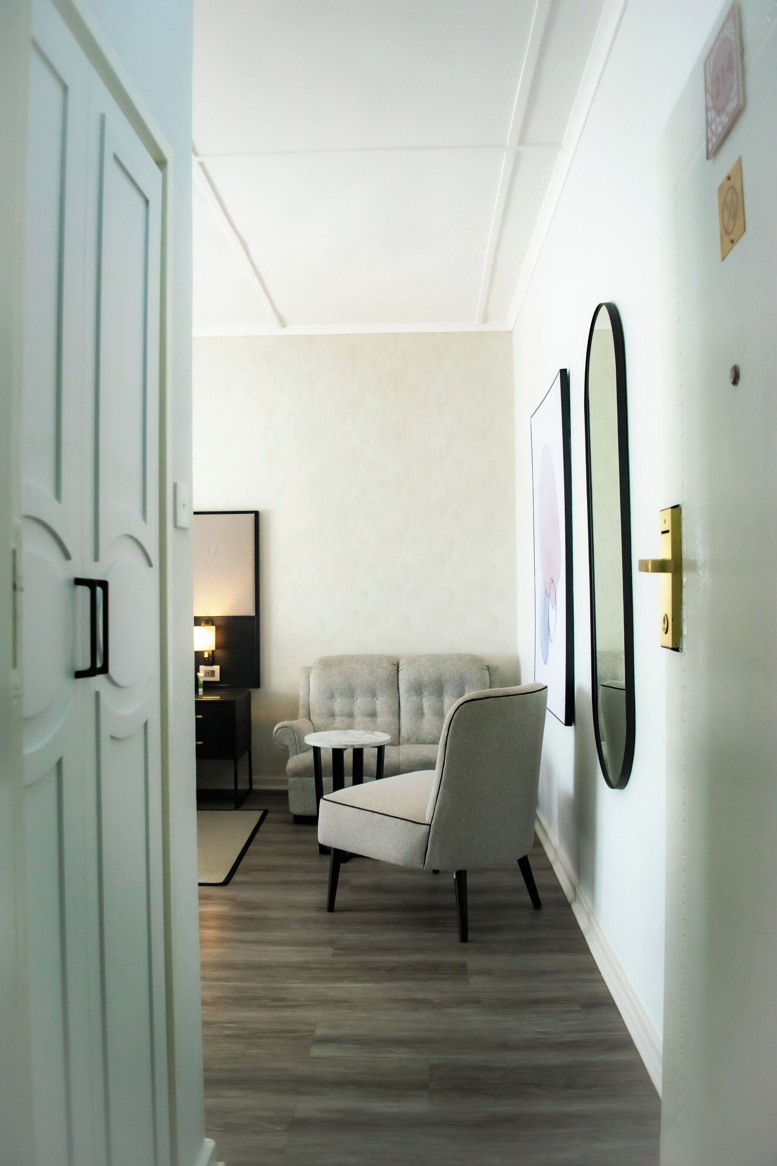A hallway with a sofa, a small table, and framed pictures on the wall.