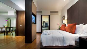A hotel room with a bed, bedside table, lamp, and a view into the bathroom.