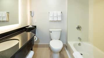 Une salle de bain moderne équipée de toilettes, d’un lavabo et d’une baignoire.