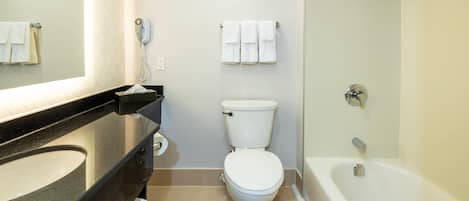 A modern bathroom with a toilet, sink, and bathtub.