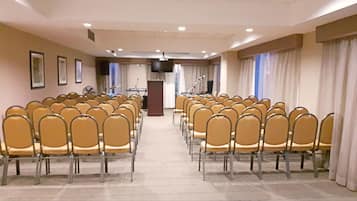 A conference room with rows of chairs facing a podium.
