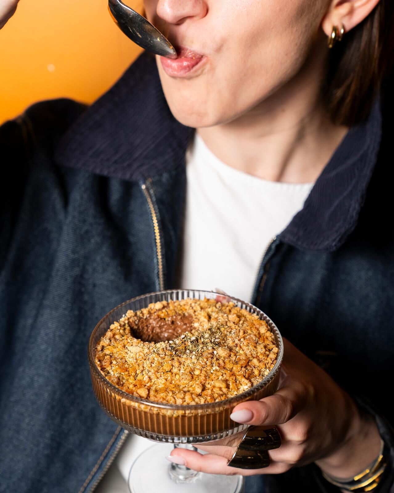 Una persona sosteniendo un postre en un recipiente de vidrio.