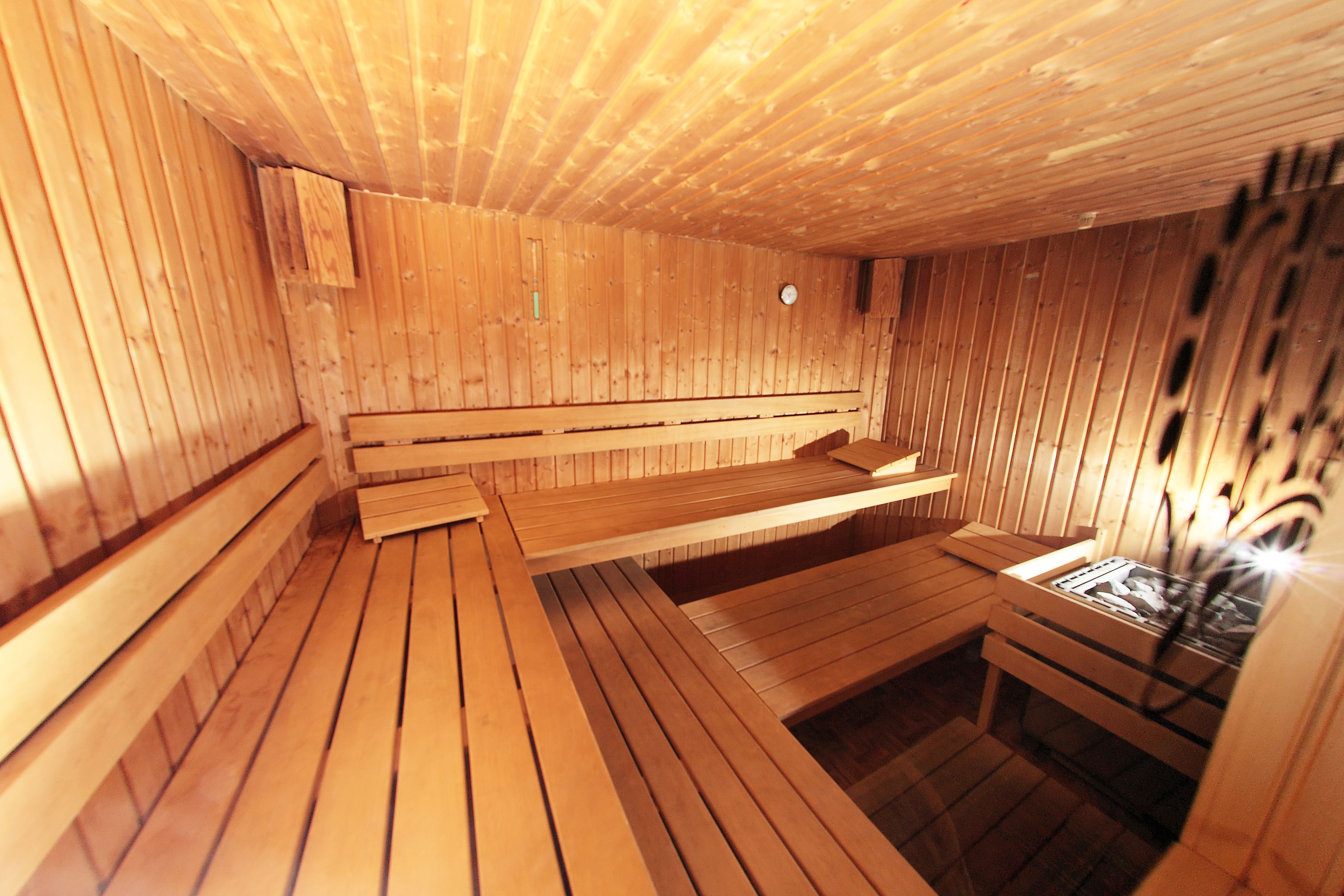 A sauna with wooden benches and a bench with a small table.