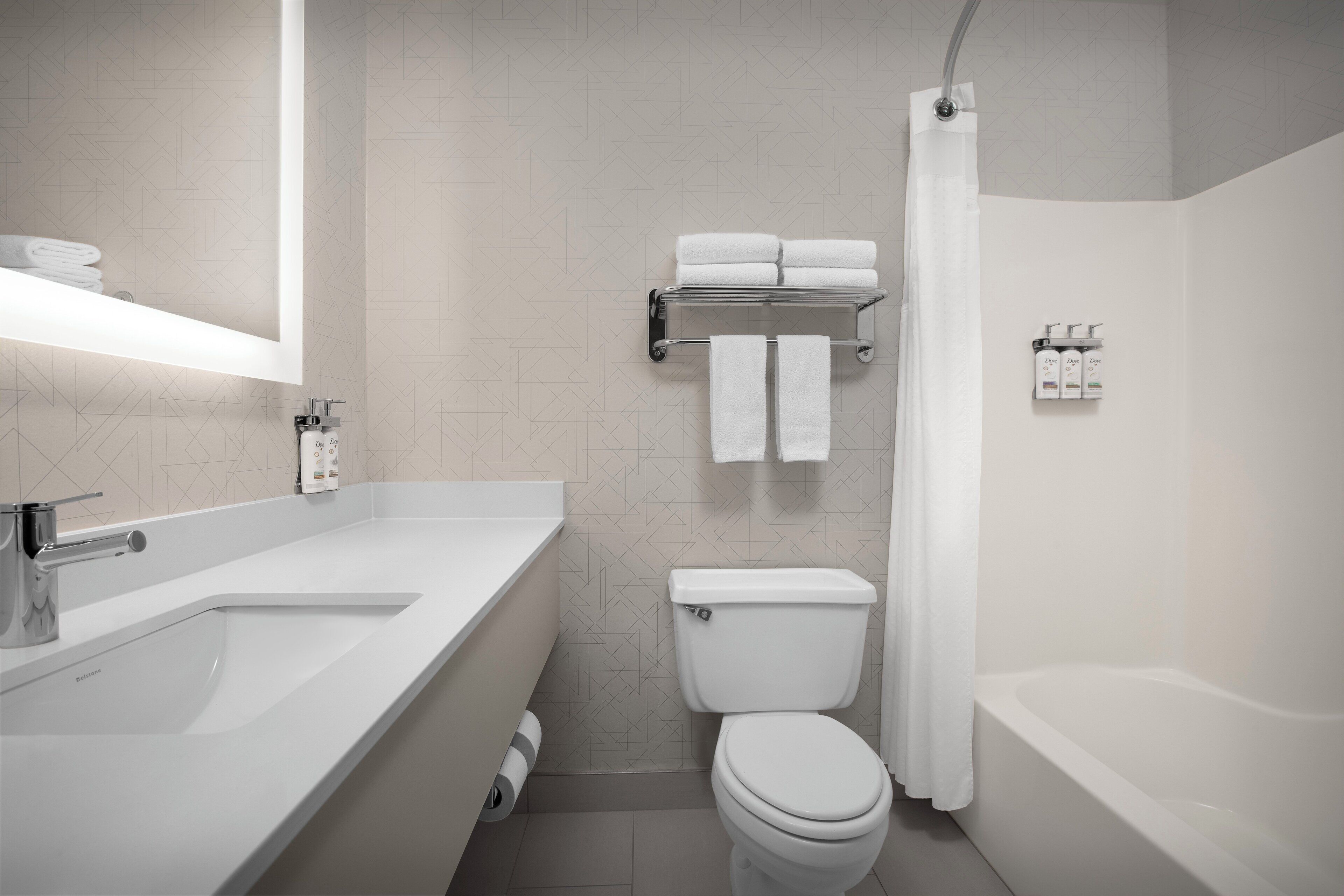 Een moderne badkamer met een wastafel, toilet en bad.