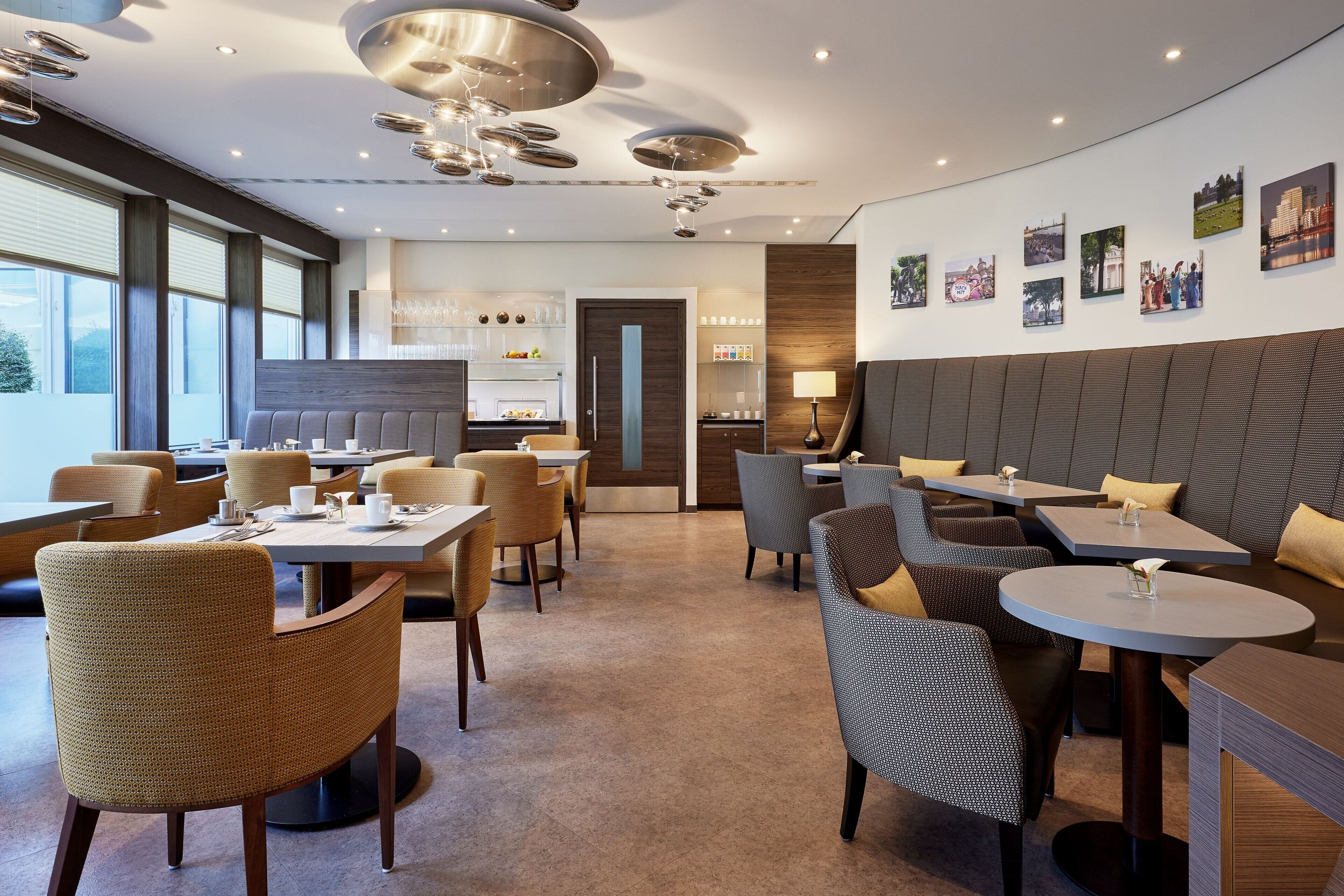 Un interior de restaurante moderno con mesas redondas, sillas de mimbre y una zona de bar central.