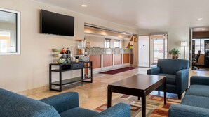 A modern hotel lobby with a reception desk, seating area, and a flat-screen TV mounted on the wall. - Quality Inn & Suites Limon (Limon)