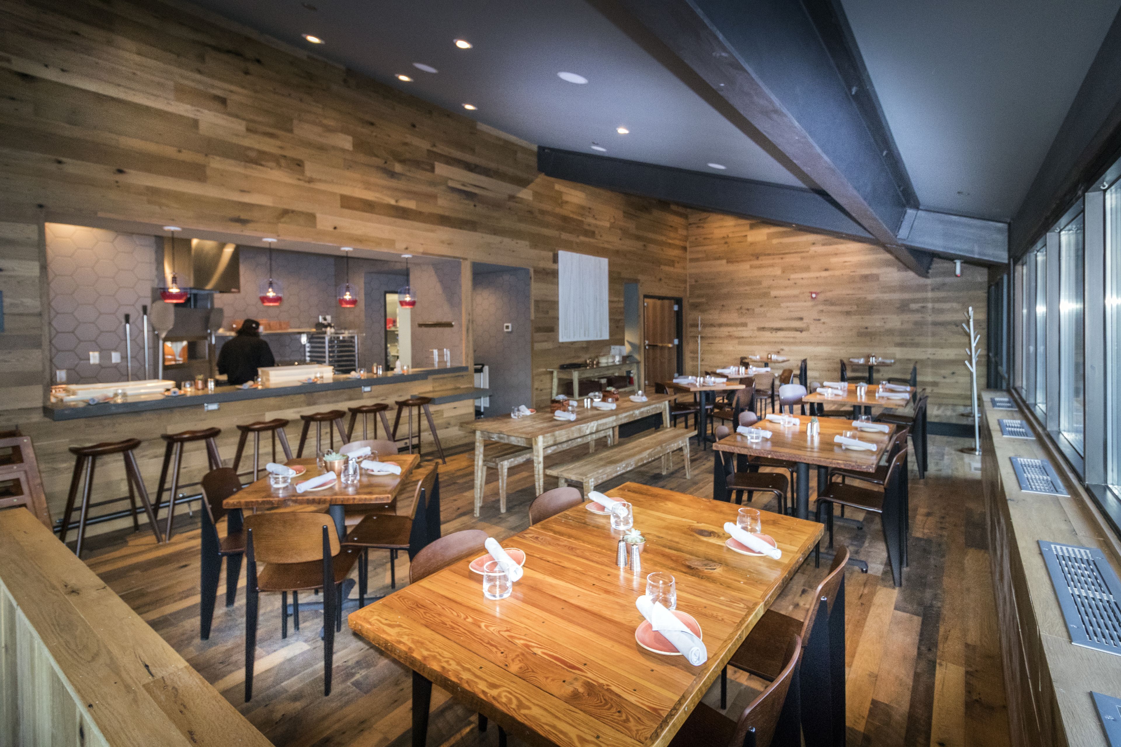 A restaurant with wooden walls and tables set for dining.