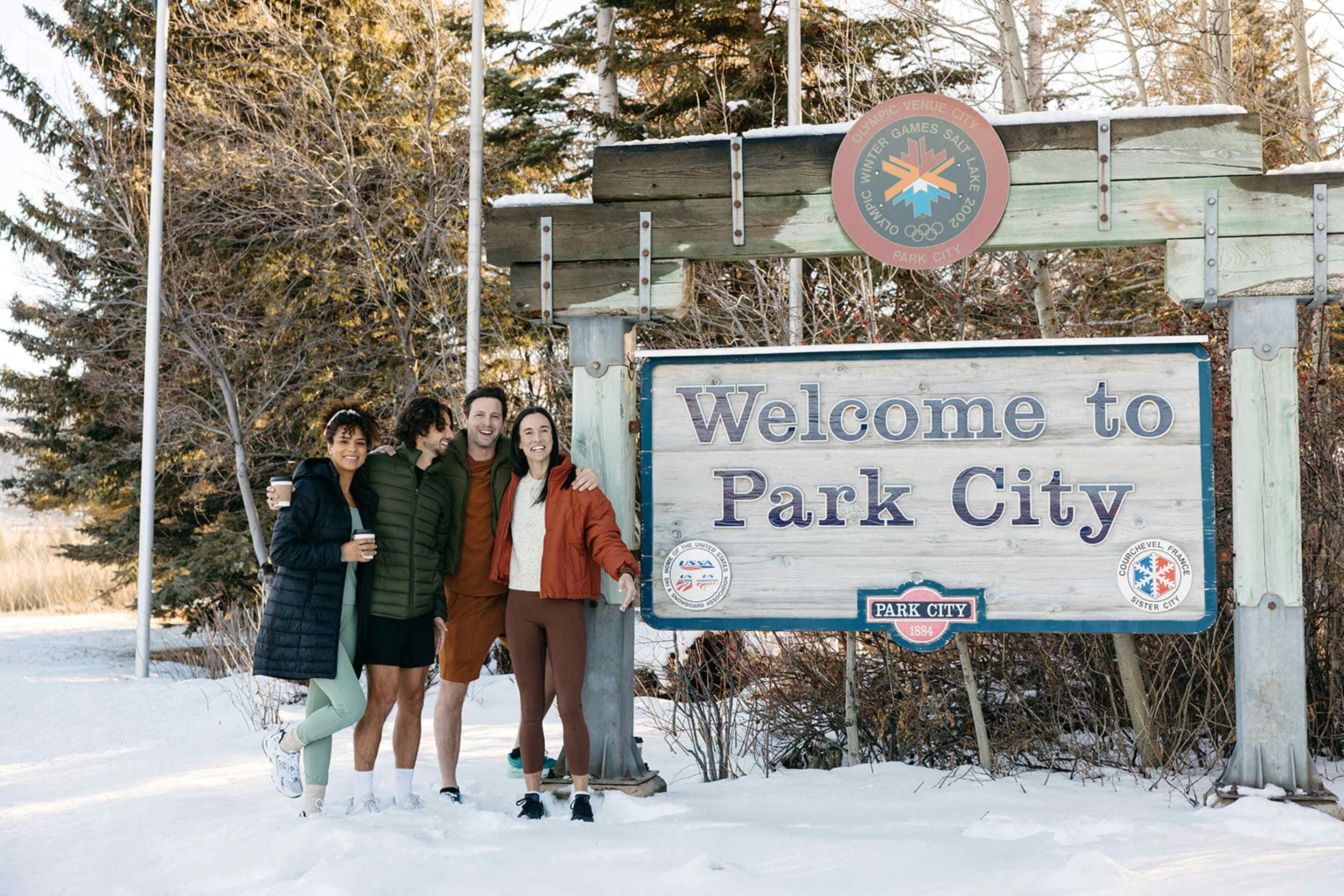 A wooden sign with "Welcome to Park City" and a logo for the 2016 Winter Olympics.