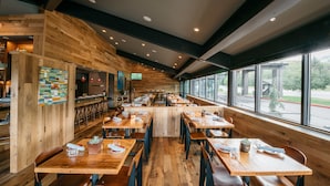 A restaurant with wooden walls and tables, large windows, and a fire extinguisher on the ceiling. - Hotel Thaynes, Park City, a Tribute Portfolio Hotel (Park City)