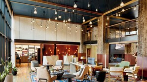 A spacious lobby with multiple seating areas, a central coffee table, and hanging light fixtures. - Hotel Thaynes, Park City, a Tribute Portfolio Hotel (Park City)