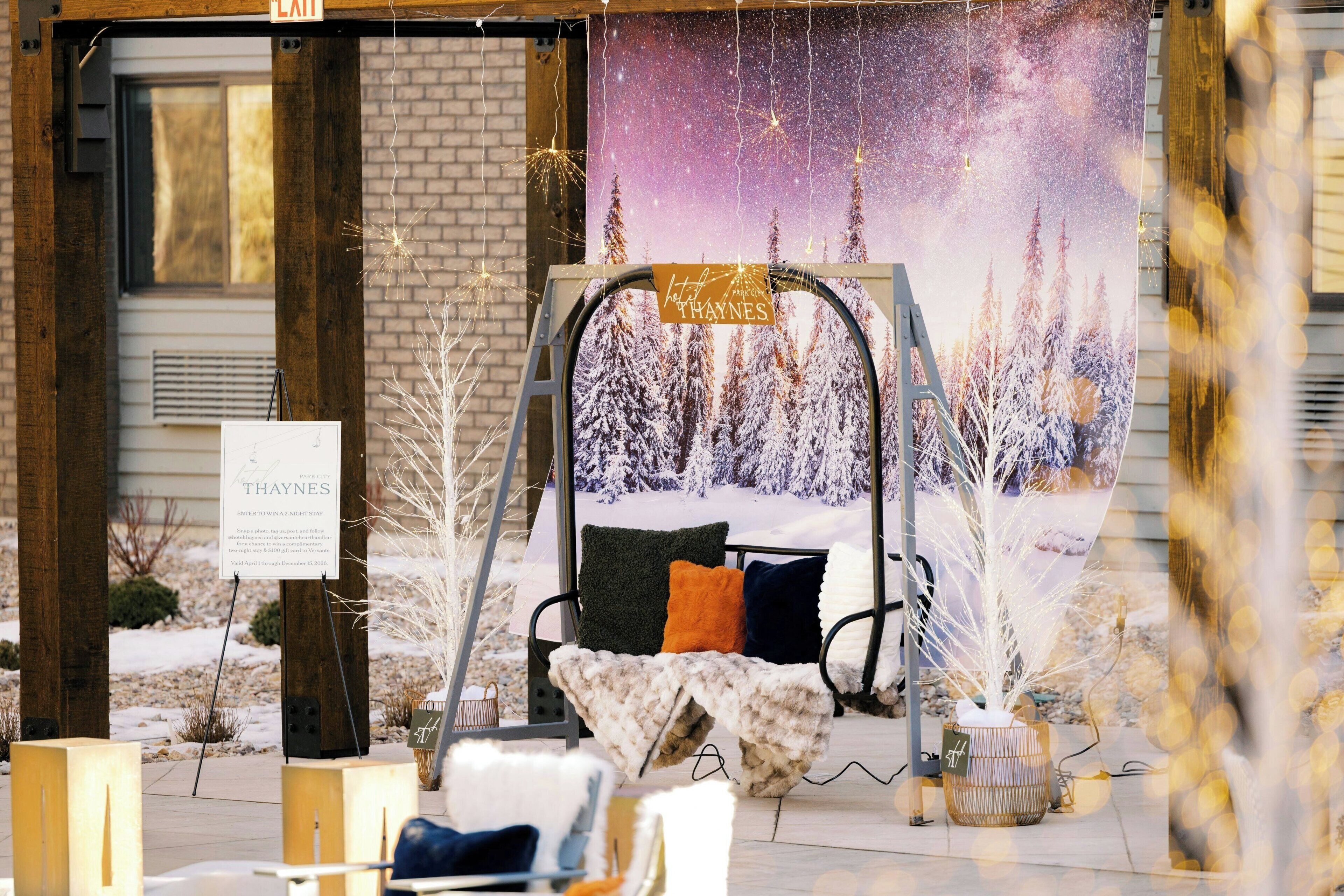 A swing chair with cushions, a sign, and a winter-themed backdrop.