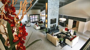 A spacious lobby with a fireplace, seating areas, and a large window. - DoubleTree Suites by Hilton Tucson Airport (Tucson)