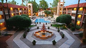 A hotel courtyard with a central fountain, a swimming pool, and multiple balconies. - DoubleTree Suites by Hilton Tucson Airport (Tucson)