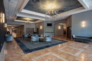 Relax in our spacious lobby area, featuring a large seating area with sofas and armchairs around a central coffee table.