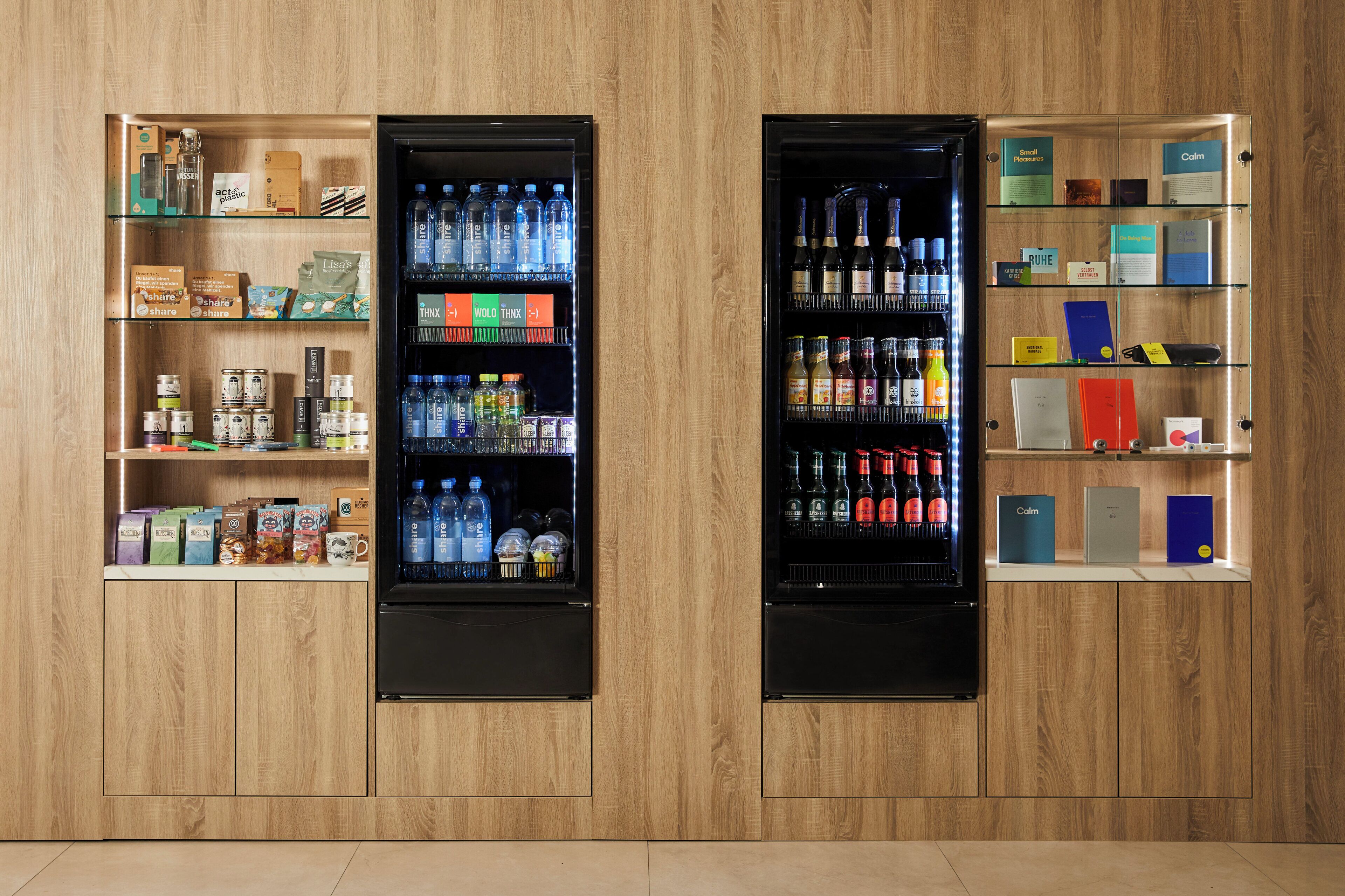 Two vending machines with various products, including beverages and snacks, against a wooden wall.