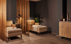 Una habitación moderna con sofá, una silla, lámpara de pie, planta y armario.