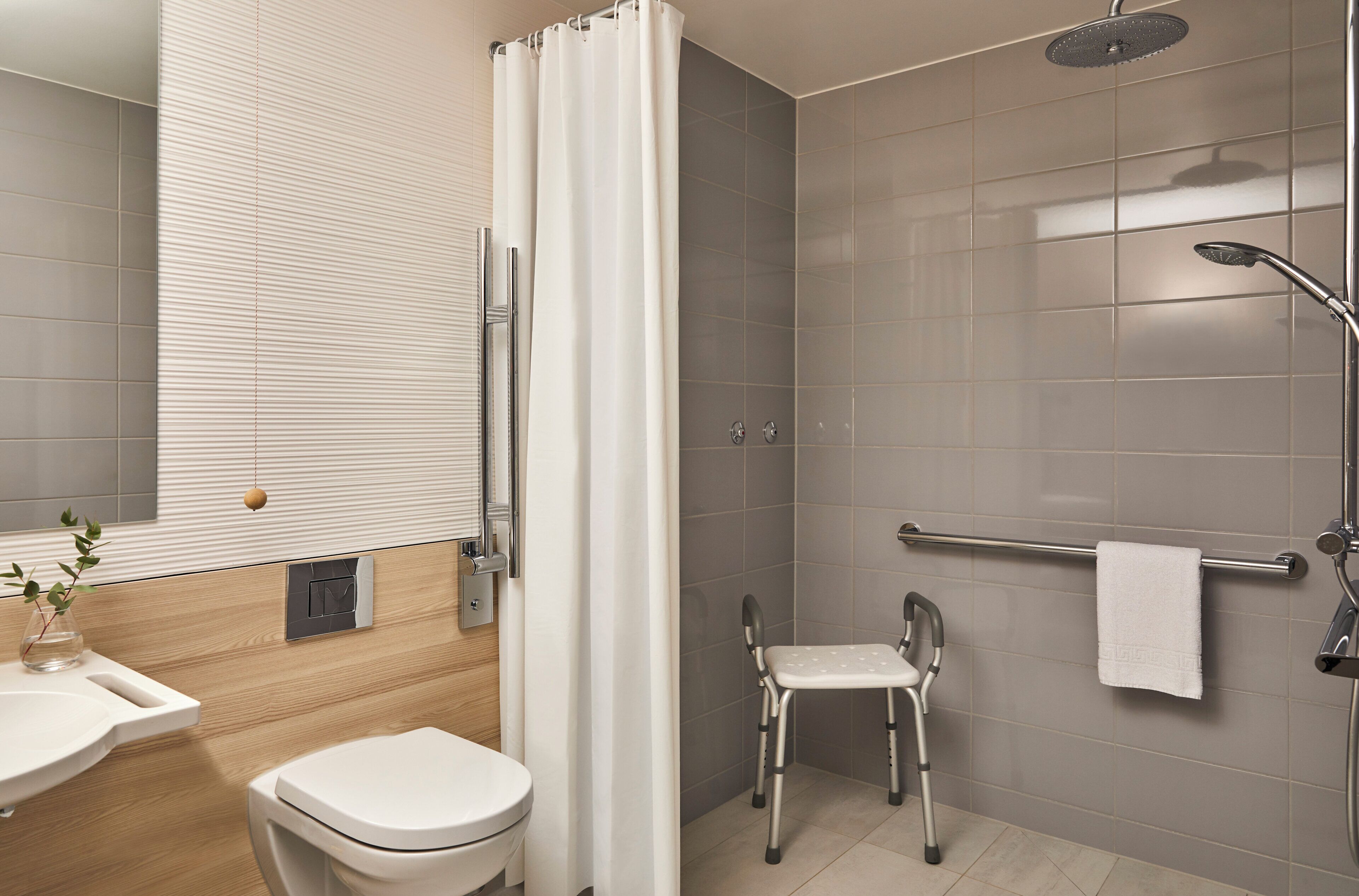 Een moderne badkamer met een douche, toilet en wastafel.