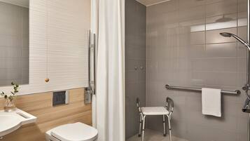 A modern bathroom with a shower, toilet, and sink.