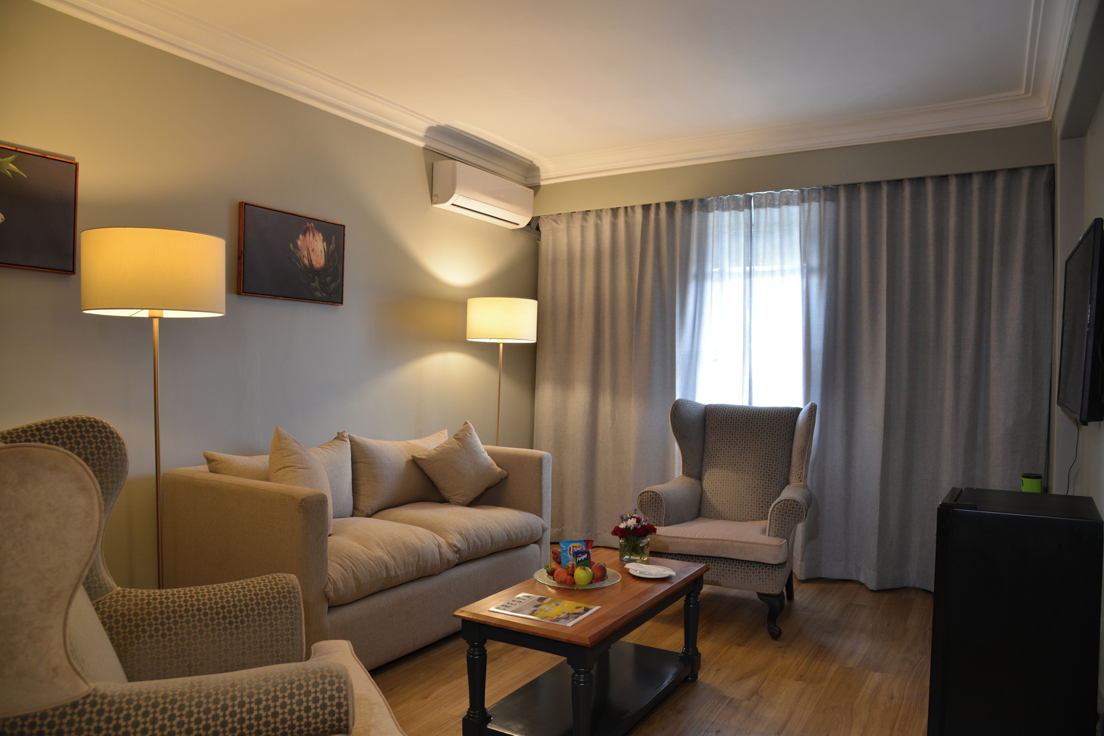 Un salon comprenant un canapé, des fauteuils, une table basse et un téléviseur à écran plat.