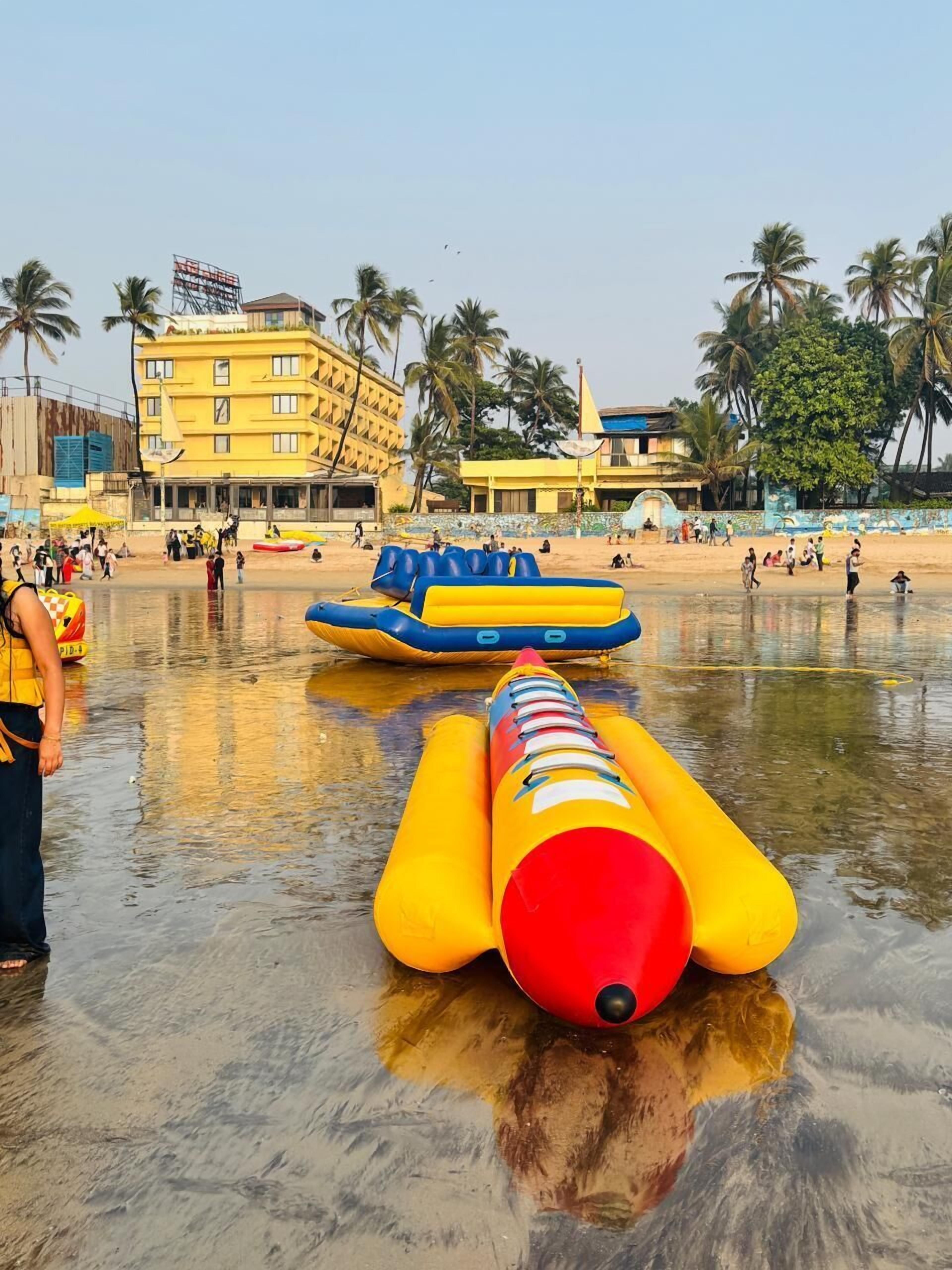 A beach with inflatable rafts and palm trees.