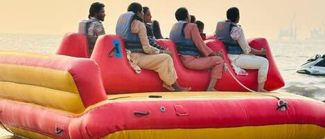 A group of people on a red and yellow inflatable raft on a body of water.