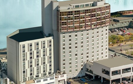 A high-rise hotel with a modern architectural design, featuring a prominent corner section with large windows.