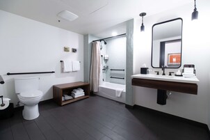 Une salle de bain moderne comprenant des toilettes, une douche et un espace lavabo.