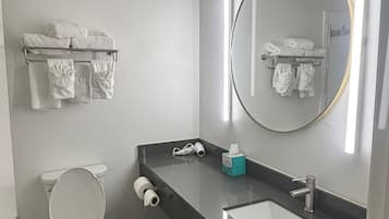 A modern bathroom with a toilet, sink, and towel rack.