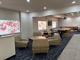 A conference room with a large table, multiple chairs, and a carpeted floor.