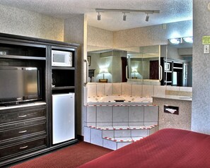 A hotel room with a minibar, a mirror, and a red carpeted area. - Quality Inn & Suites Gibsonia - Pittsburgh North (Gibsonia)