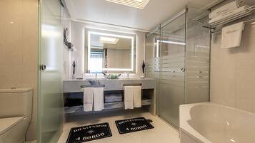 Un baño moderno con cabina de ducha de vidrio, un espejo grande y una bañera.
