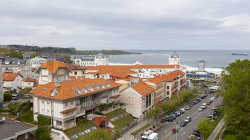 Un paisaje urbano costero con edificios históricos, un puerto deportivo y vista al mar.