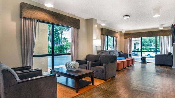 A spacious lobby with a wooden floor, large windows, and modern seating including sofas and armchairs. - Best Western Oak Manor (Biloxi)