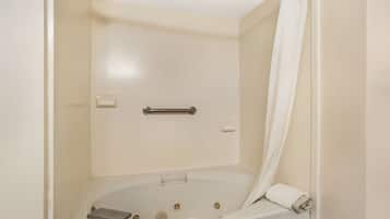 A bathroom with a bathtub, a shower curtain, and a towel rack.