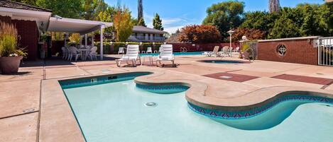 Una piscina al aire libre de temporada, sillones reclinables de piscina