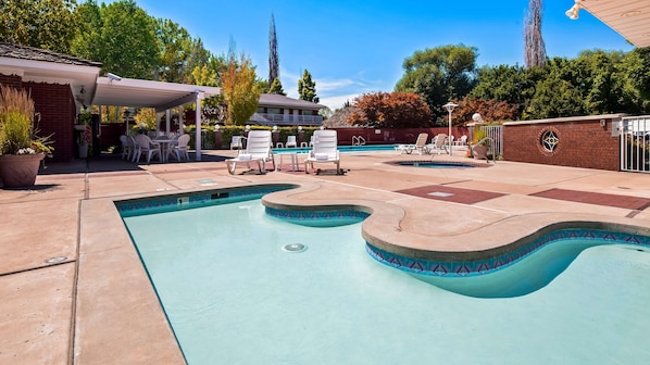 Una piscina al aire libre de temporada, sillones reclinables de piscina