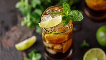 A glass of iced tea garnished with a lime slice and mint leaves.