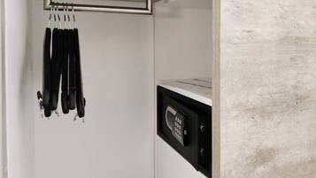 A kitchen with a built-in microwave and a hanging rack for utensils.