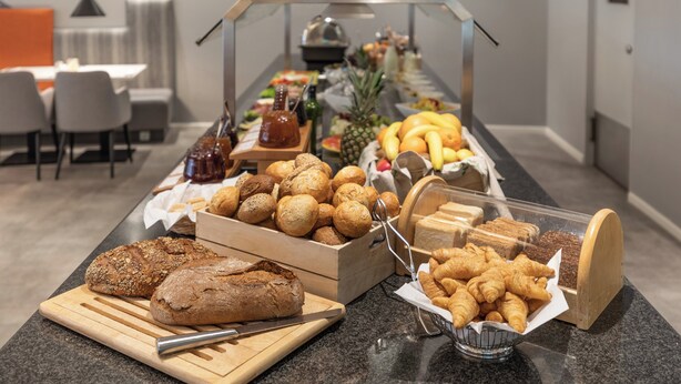 A buffet with various breads, pastries, and fruits. - Garner Hotel Wiesbaden City by IHG (Wiesbaden)