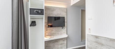 A modern bathroom with a shower, a vanity with a mirror, and a towel rack.