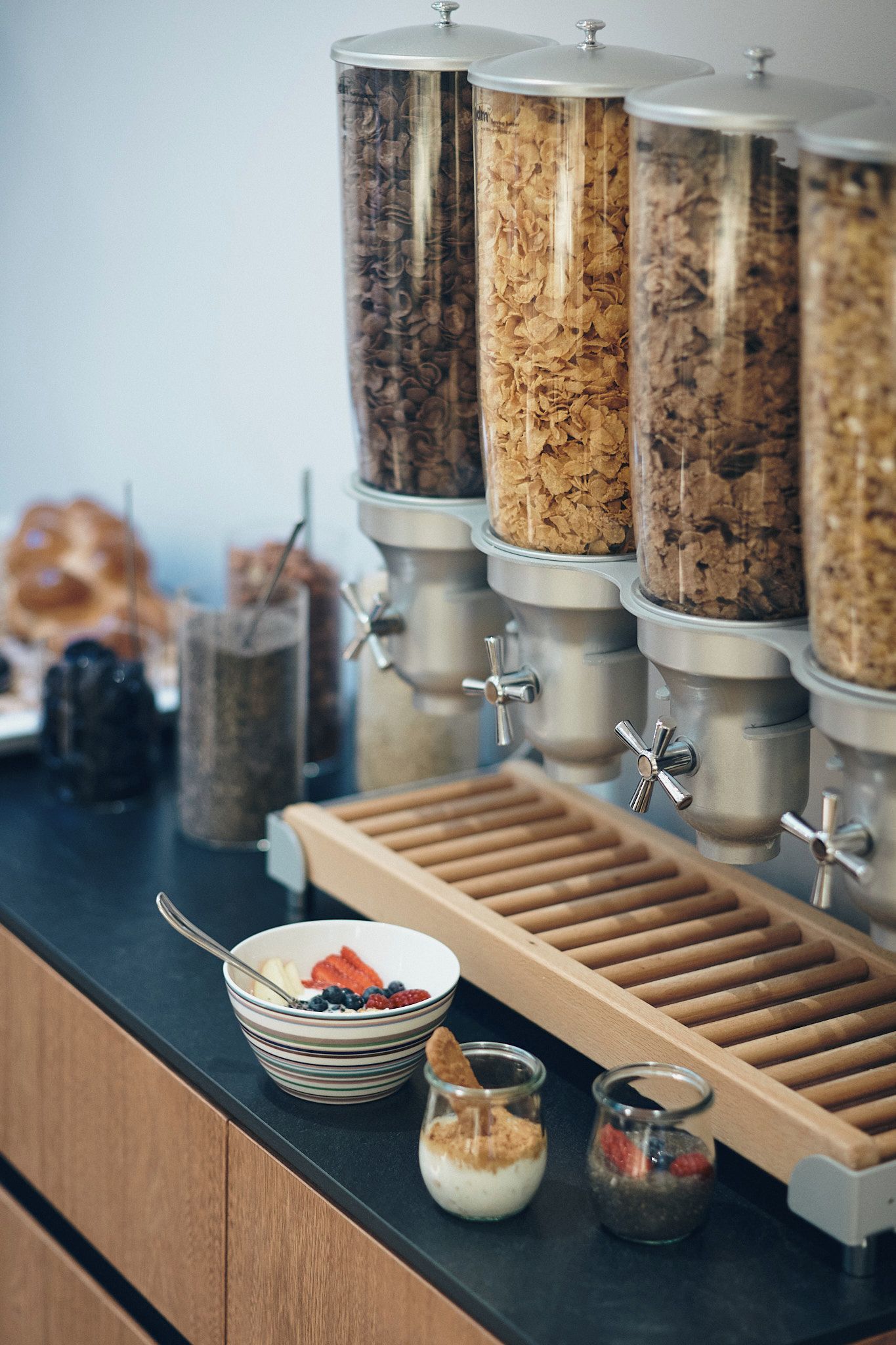 Un comptoir de petit-déjeuner avec plusieurs boîtes de céréales et un plateau de fruits.