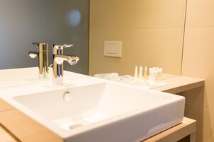 Un baño moderno con dos lavabos, un espejo y artículos de aseo en la encimera.