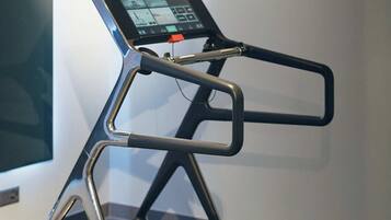 A treadmill with a digital display and a stationary bike in the foreground.