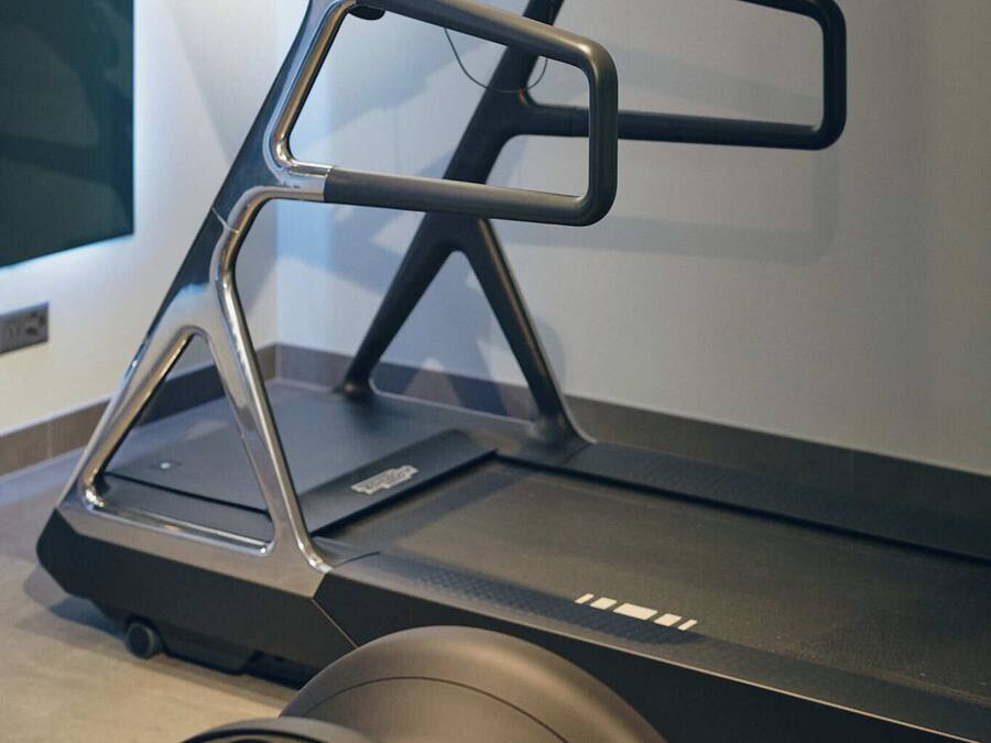 A treadmill with a digital display and a stationary bike in the foreground.